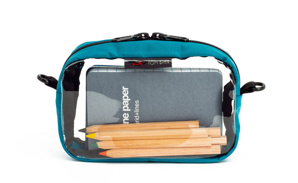 A Viridian blue-green 3D Clear Organizer Cube filled with sundries.